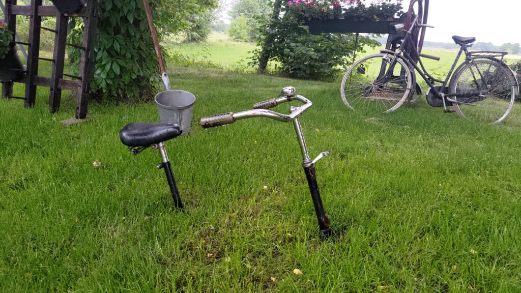 Une tige de selle dz vélo avec une selle et un guidon. Enfoncés dans l'herbe, on dirait que tout le vélo est dans le sol sauf ce qui dépasse