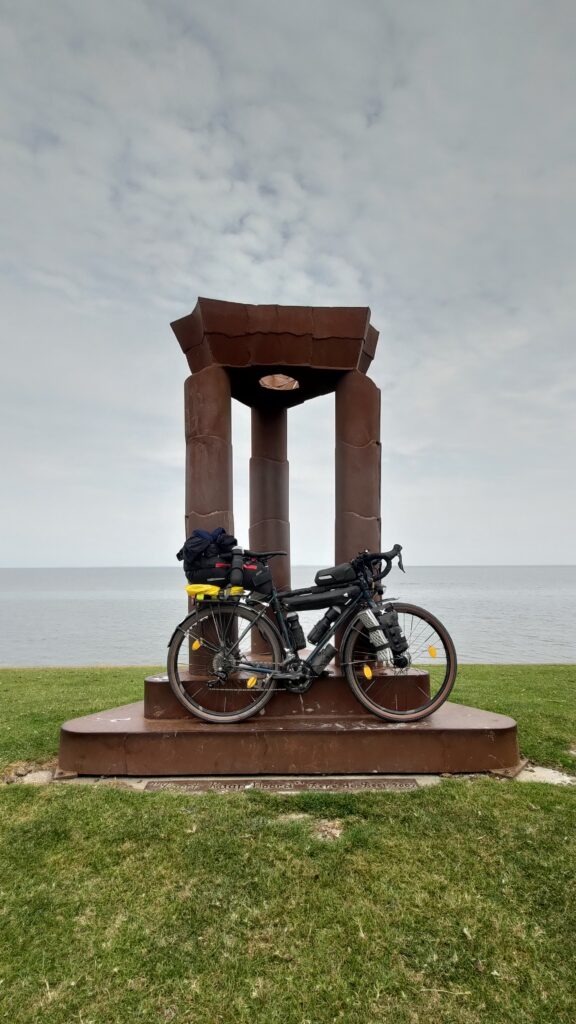 Monument formé de 3 piliers surmontes d'une couronne, un vélo posé devant