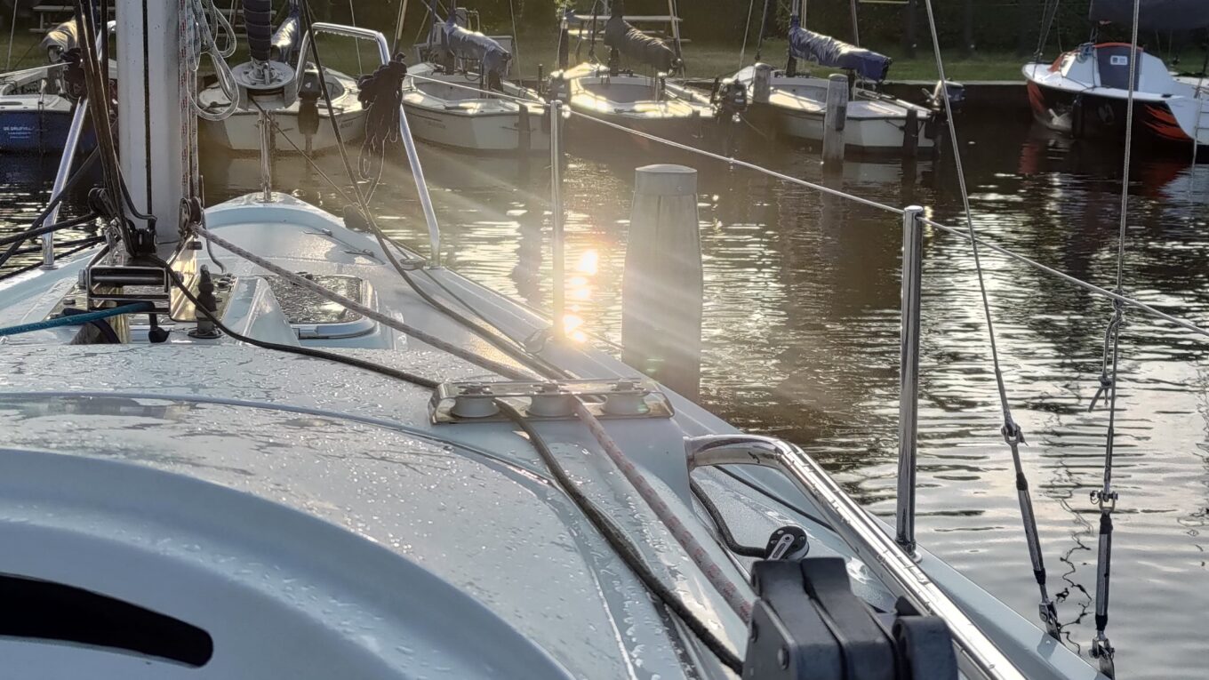 Depuis un petit voilier habitable vue sur l'eau et le soleil qui se reflète