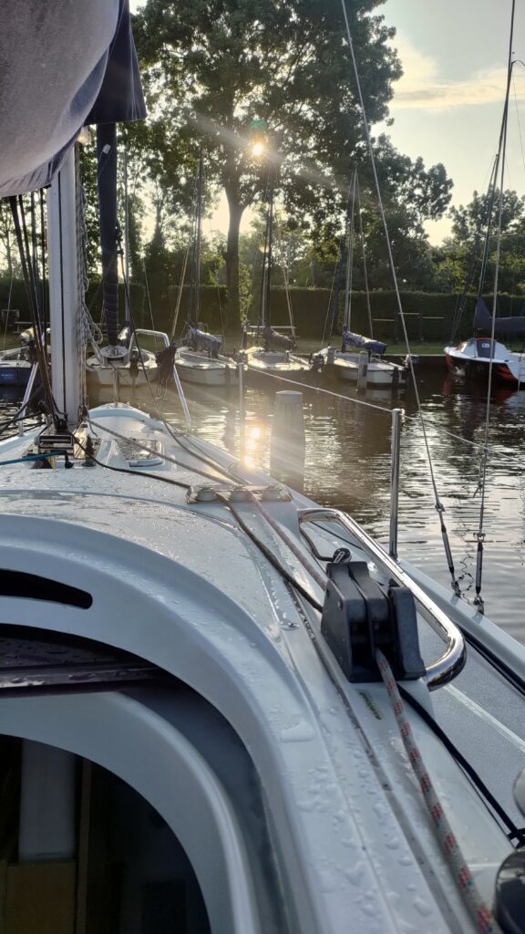 Depuis un petit voilier habitable vue sur l'eau et le soleil qui se reflète