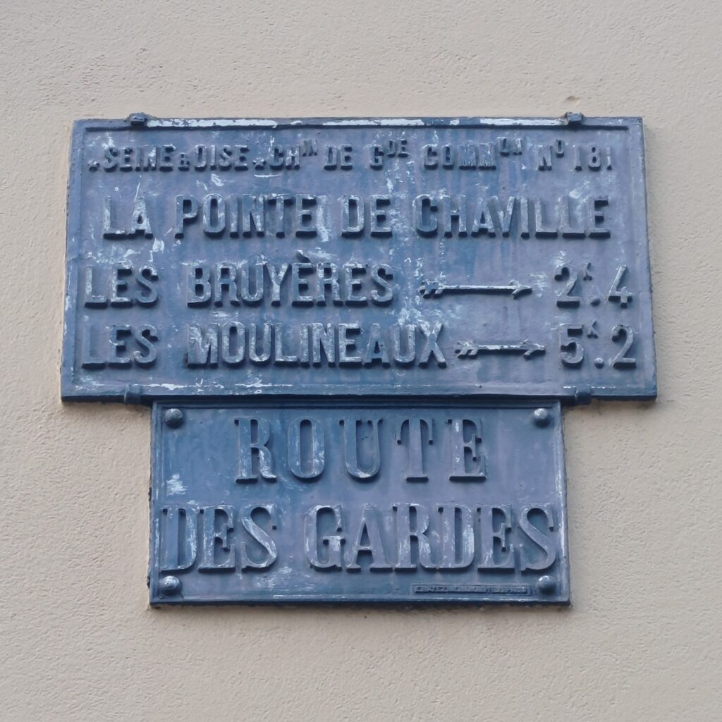 Panneau de rue historique Route des Gardes. Un autre panneau au-dessus de la même époque indique des distances depuis Chaville vers Les Bruyères (2,4km) et vers Les Moulineaux (5,2km)