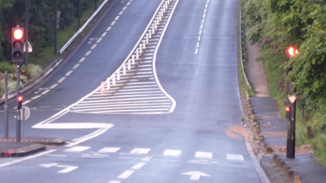 Rue du Pavé des Gardes vue du bas de la côte. C'est une très grande montée en 2x2 voies qui bouche la vue en tournant et se perdant dans la forêt
