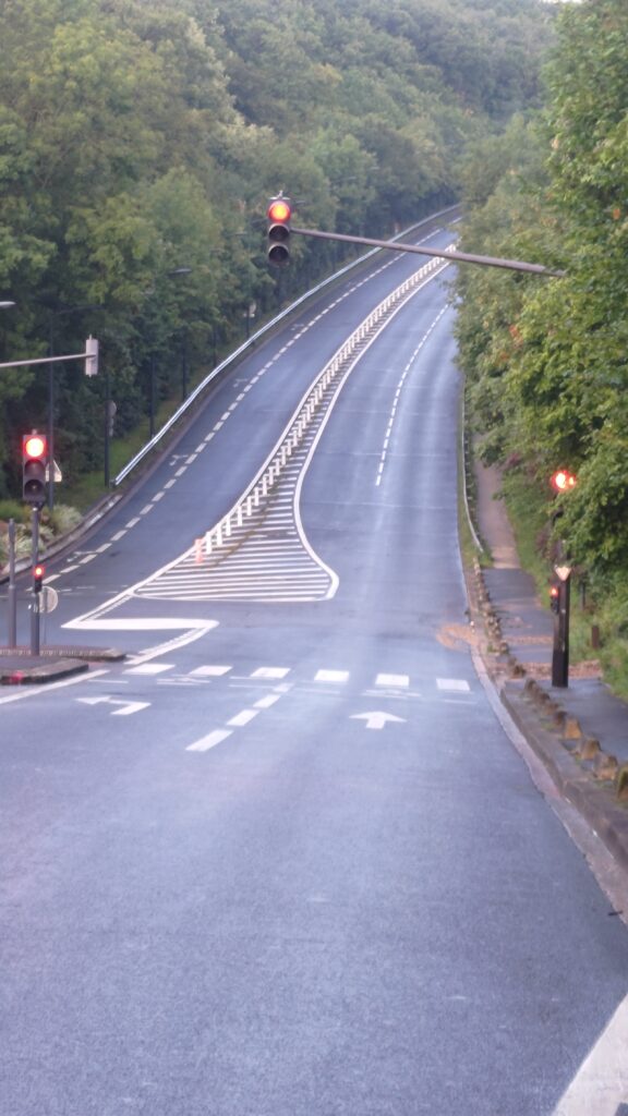 Rue du Pavé des Gardes vue du bas de la côte. C'est une très grande montée en 2x2 voies qui bouche la vue en tournant et se perdant dans la forêt