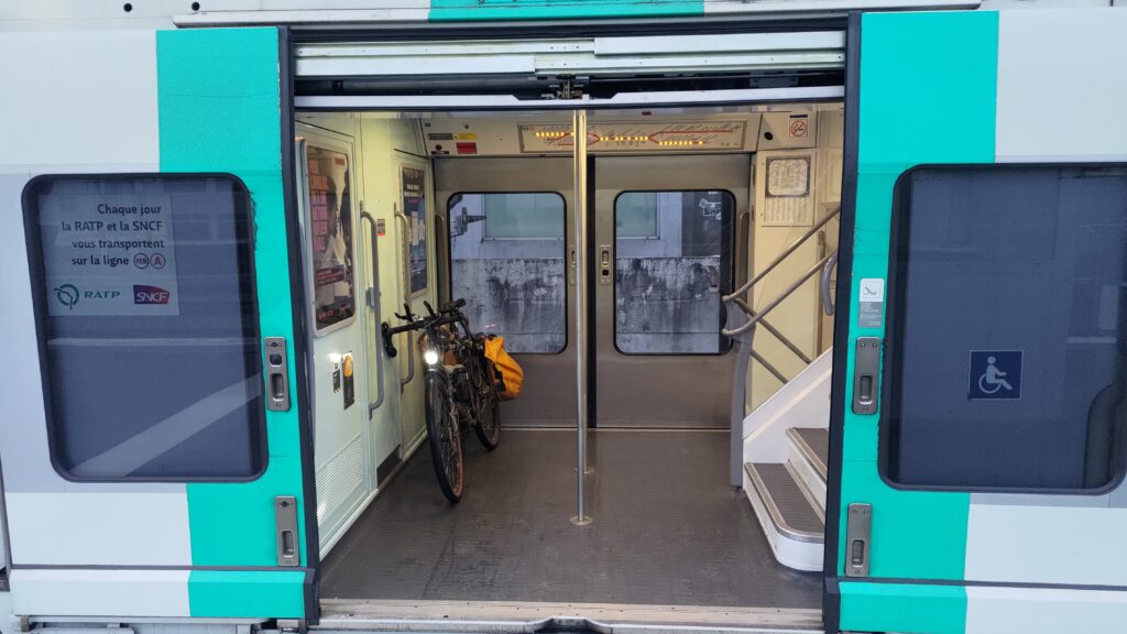 Double porte grande ouverte d'un RER parisien vu depuis le quai avec un vélo à l'intérieur