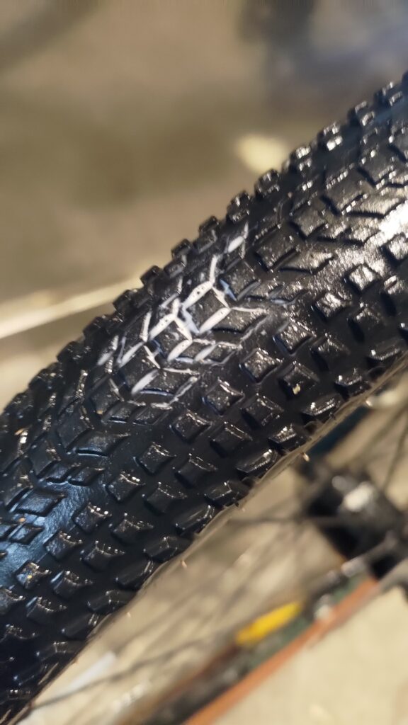 Pneu de vélo mouillé avec du liquide préventif blanc qui s'échappe d'un trou