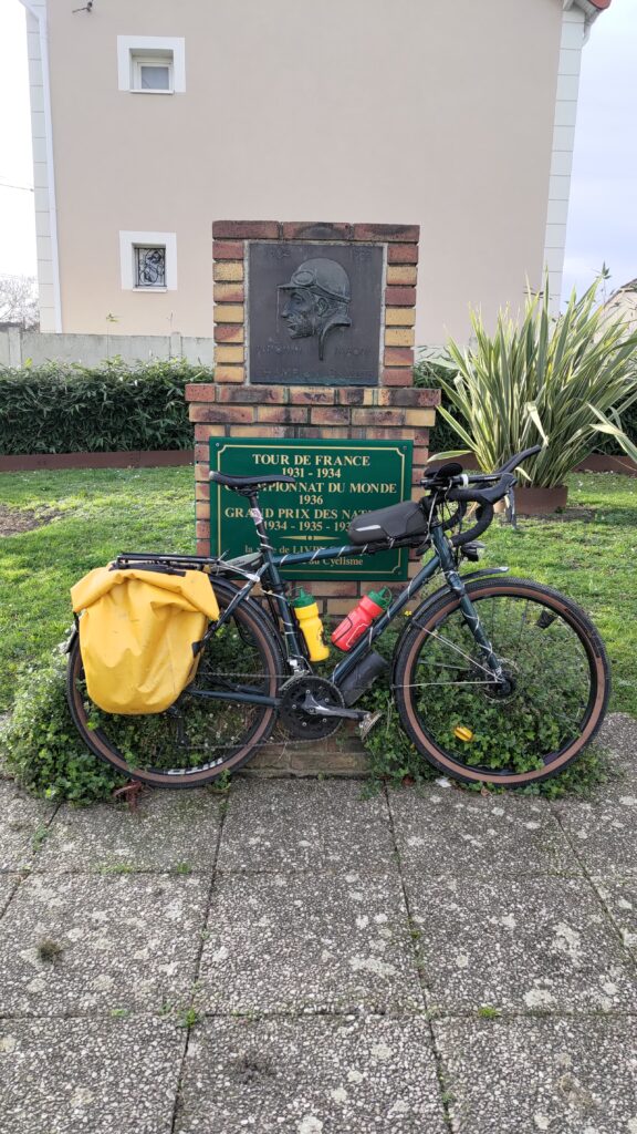 Un vélo posé devant une stelle en hommage à Antonin Magne