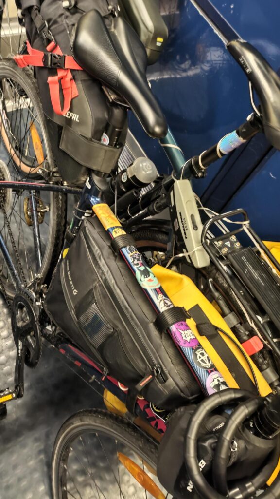 Deux vélos l'un contre l'autre dans un RER. Vue en plongée et plan serré les vélos de type route ne sont pas visibles en entier. Ils sont équipés de sacoches ou de sacs bikepacking.
