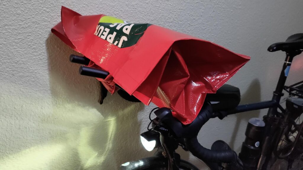 Un sac de course qui est posé sur des prolongateurs type triathlon sur un vélo gravel