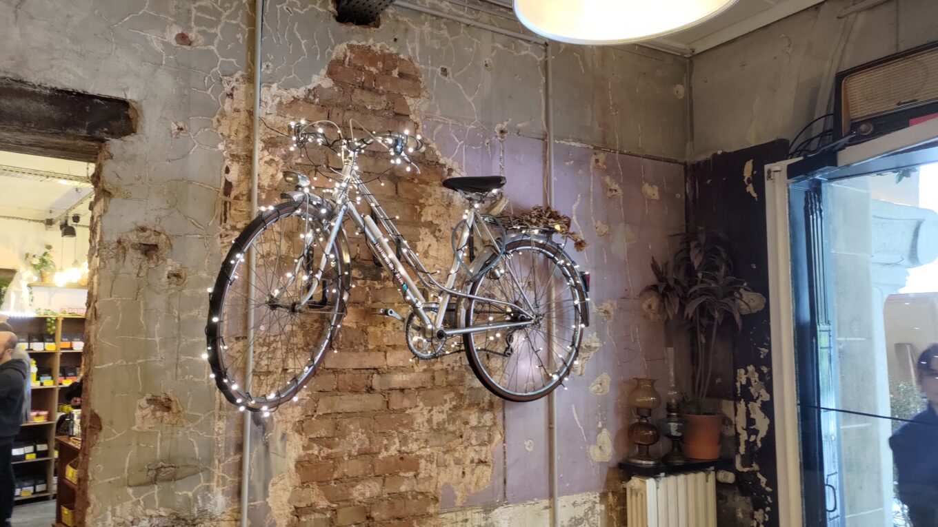 Vélo recouvert d'une guirlande lumineuse accroché sur le mur d'un bar complètement défraîchi