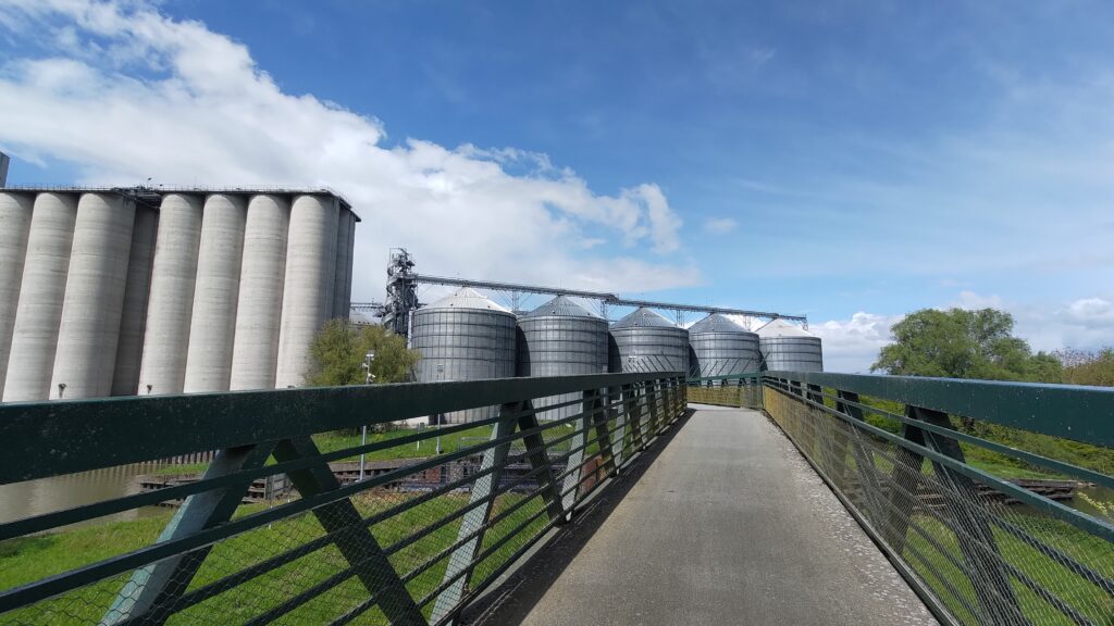 Passerelle cycliste avec vue sur des silos