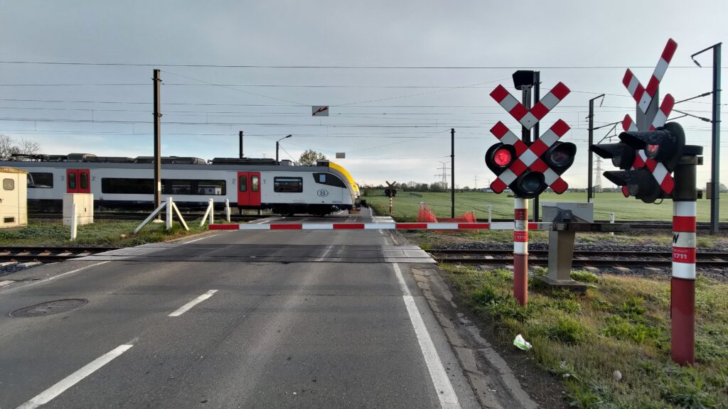 Route, passage à niveau fermé et train traversant