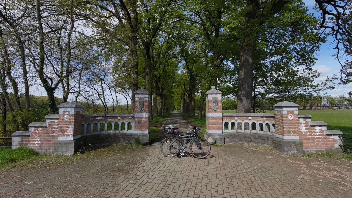 Vue de l'entrée de l'abbaye de Westmalle, un vélo de profil est centré sur l'entrée