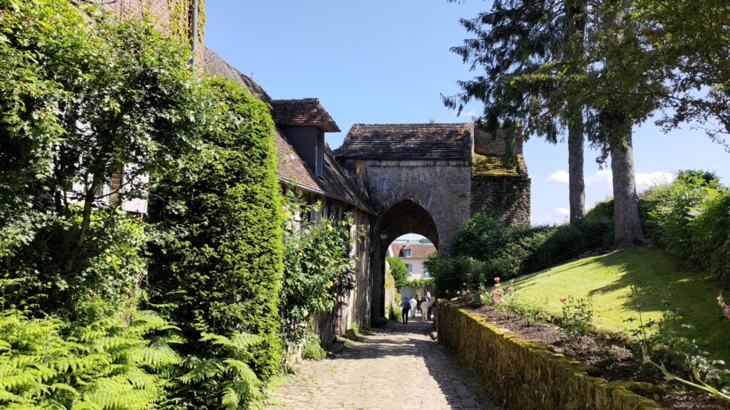 Vue d'un petit village, une maison passe au-dessus d'une petite route piétonne et forme une arche