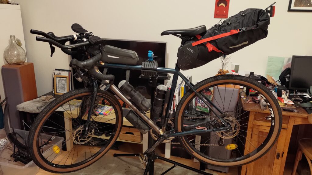 Vélo monté et équipé sur un pied d'atelier. Le tube diagonal du cadre est toujours acier non peint car neuf