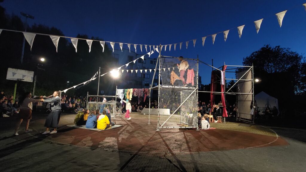 De nuit, dans une cours d'école, des échafaudages servent de décors pour un spectacle de danse