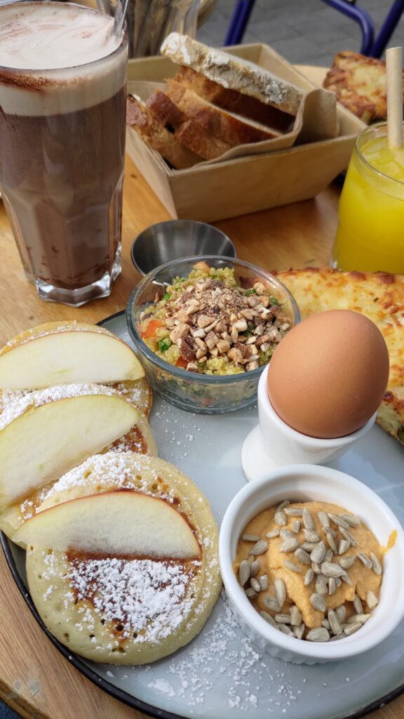 Un brunch composé notamment de pancakes, œuf, guacamole, boisson chocolatée, etc…