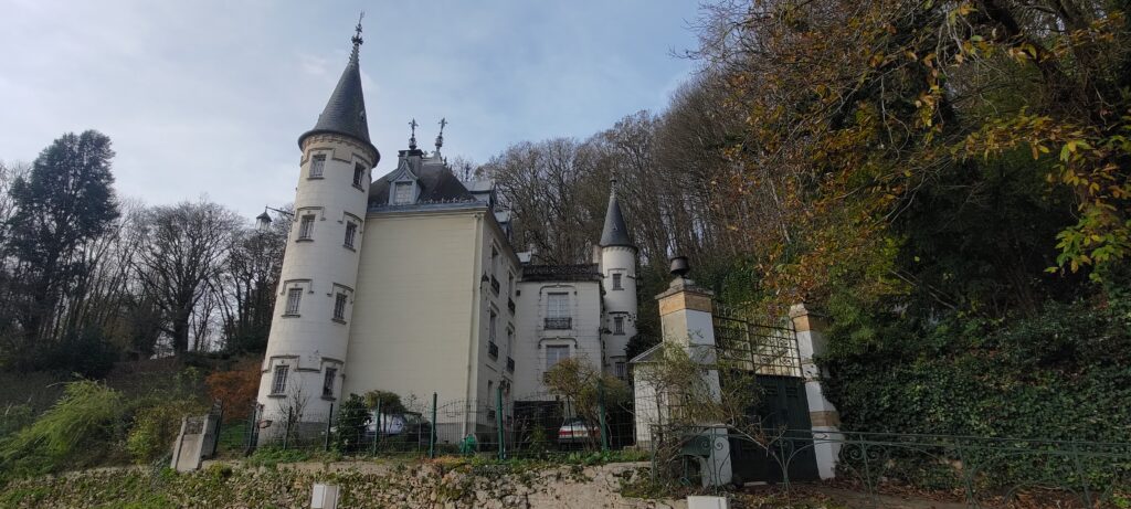 Vu d'une grande bâtisse blanche ressemblant à un château renaissance avec deux grandes tours ronde et un toit pointu