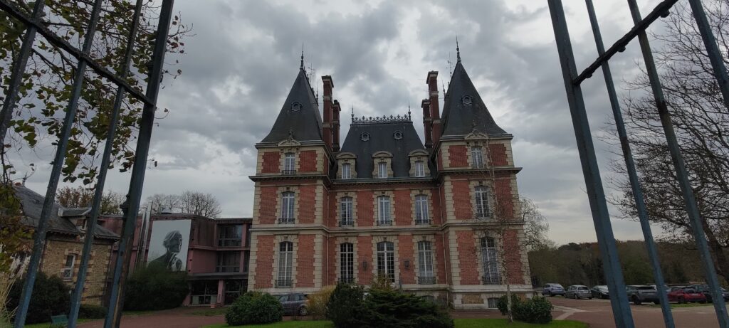 Une bâtisse bourgeoise en brique rouge, sur 3 étages avec un haut toit en tuiles