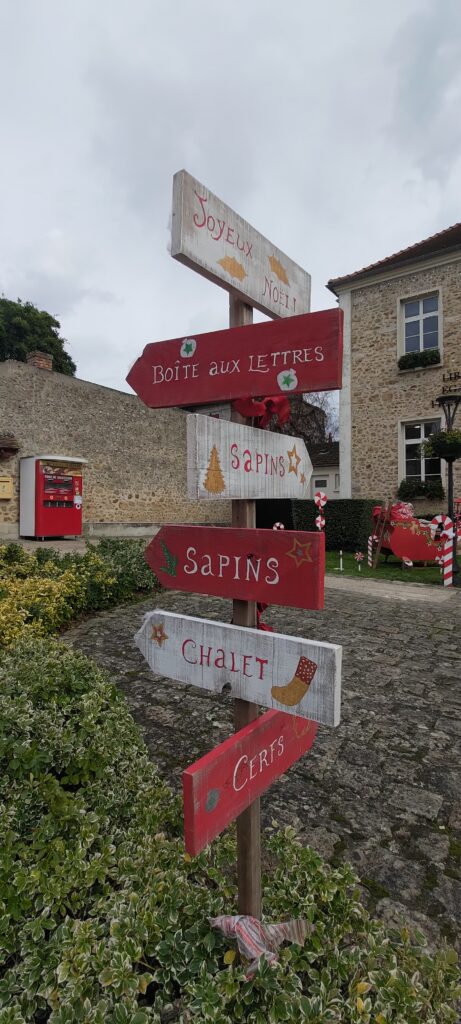 Des panneaux à côté de la mairie de Saint-Maurice-Montcouronne indiquant Joyeux Nöel et "cerfs", "chalet", "sapins"