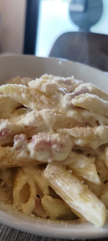 En gros plan un bol contenant un plat de penne lardon fromage