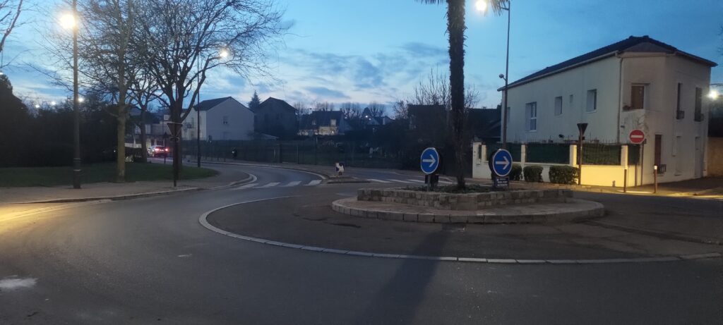 Un rond point en milieu urbain à la tombée de la nuit