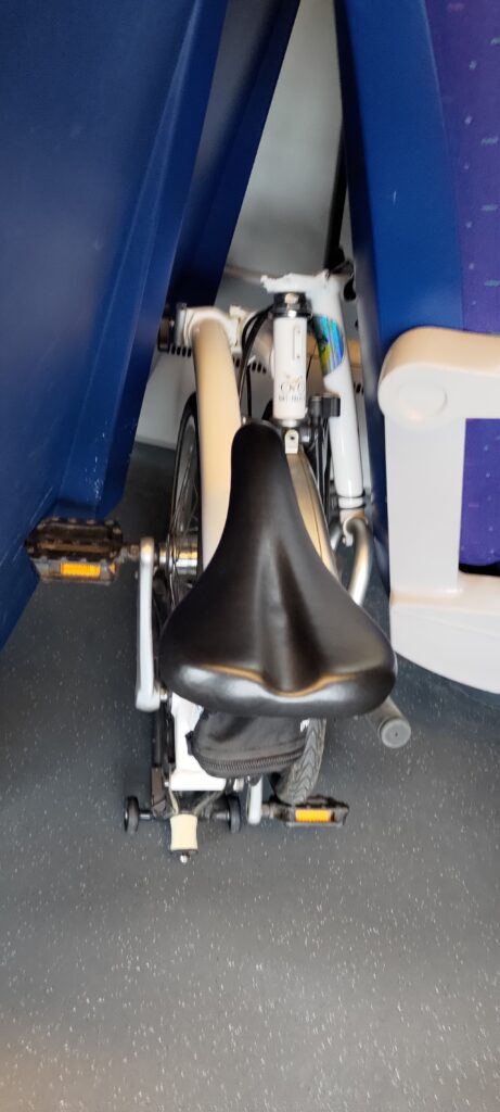 Un vélo pliant glissé entre deux sièges dans un train