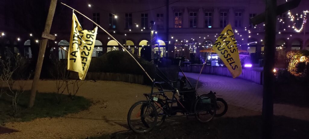 Deux vélos, un tall bike et un cargo, appuyés l'un a l'autre et tous deux ornés de drapeaux Critical Mass Brussels