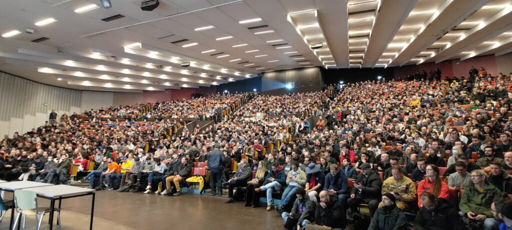 Amphithéâtre plein à craquer, vu depuis l'orateur, plusieurs centaines de personnes