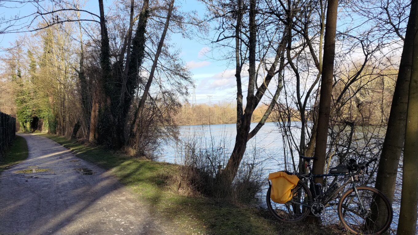 Un vélo posé sur un arbre en bord de rivière