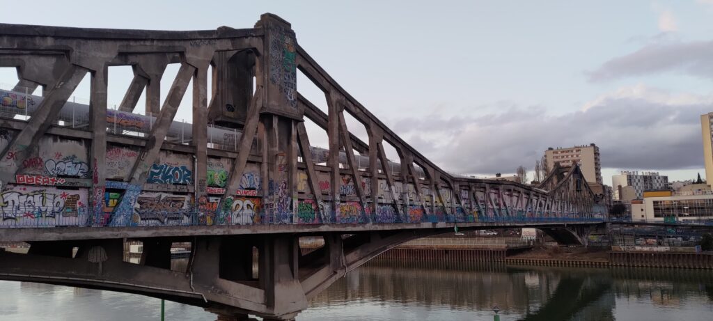 Un pont industriel en béton recouvert de tags (Passerelle aux Câbles)