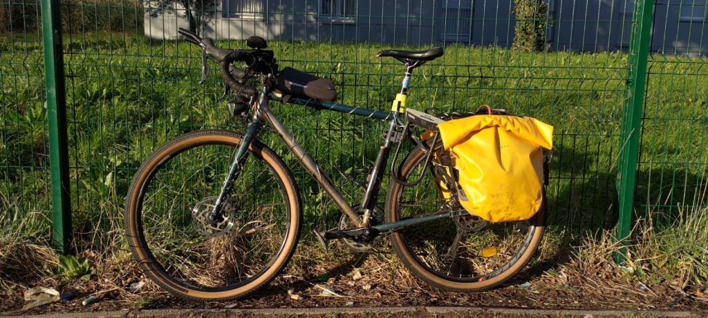 Un vélo baigné par le soleil posé sur un grillage