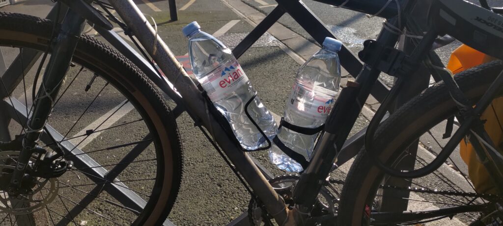 Plan serré sur un vélo dont les bidons sont des bouteilles d'eau minérale
