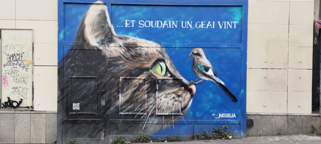 sur un mur peint en bleu; portrait d'un chat vu de profil, posé sur son nez un geai (trop petit par rapport à la taille de la tête du chat) et texte "…Et soudain un geai vint"