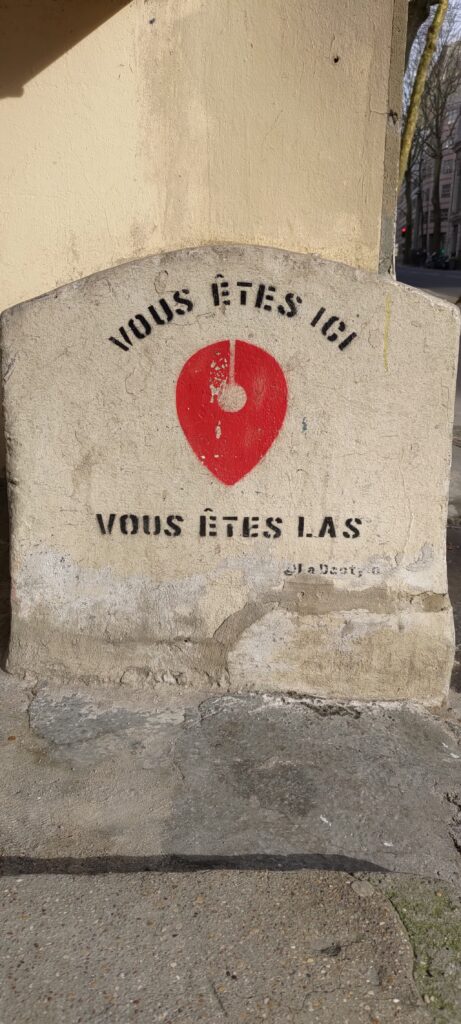 Un dessin d'une épingle comme sur une carte numérique, texte "Vous êtes ici" et en dessous "vous êtes las"