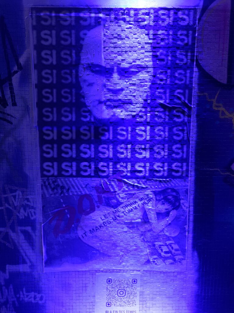 Dans une lumière de lampe bleue, un portrait d'un homme chauve de face, juste la tête, agressive et fermée (type "1984") et un texte l'entour "SI SI SI SI" répété sur toute la surface. Dessous une femme nue type asiatique est allongée sur le côté, texte "LET ME DRINK MILK IT MAKES MY TUMMY HURT" qui est posé en longueur sur son corps. QR Code pointant vers le compte Instagram https://www.instagram.com/la.fin.des.temps