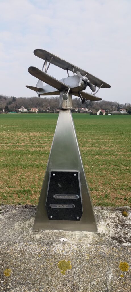 Monument métallique d'environ 1,20m de haut en forme te pyramide sur laquelle est posée un avion biplan à hélice. C'est un mémorial à Richard Broggio décédé au cours du meeting aérien de La Ferté-Alais le 26 mai 1996