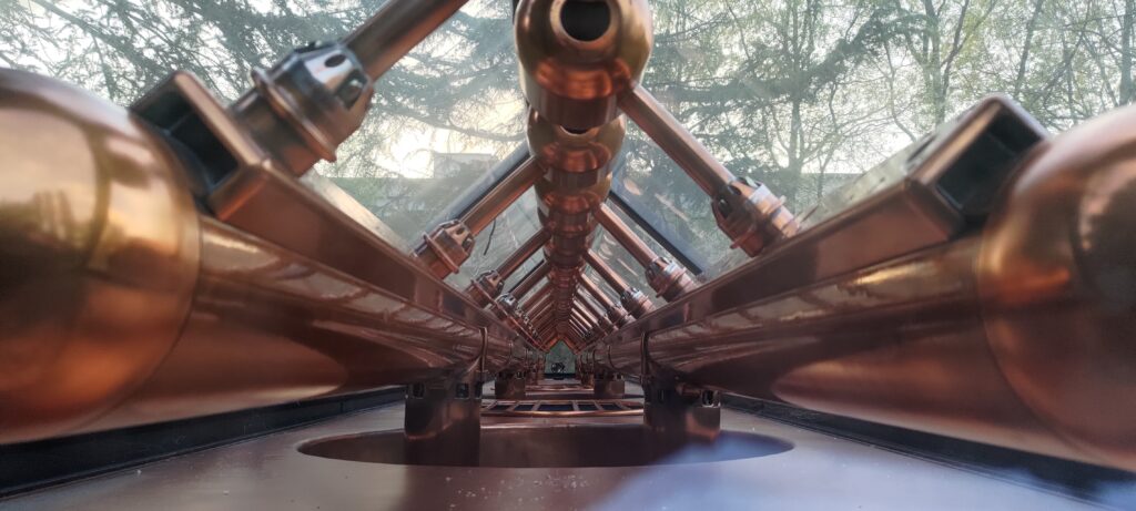 Vue dans la perspective de l'ancien accélérateur linéaire à particules en cuivre exposé dans le campus d'Orsay