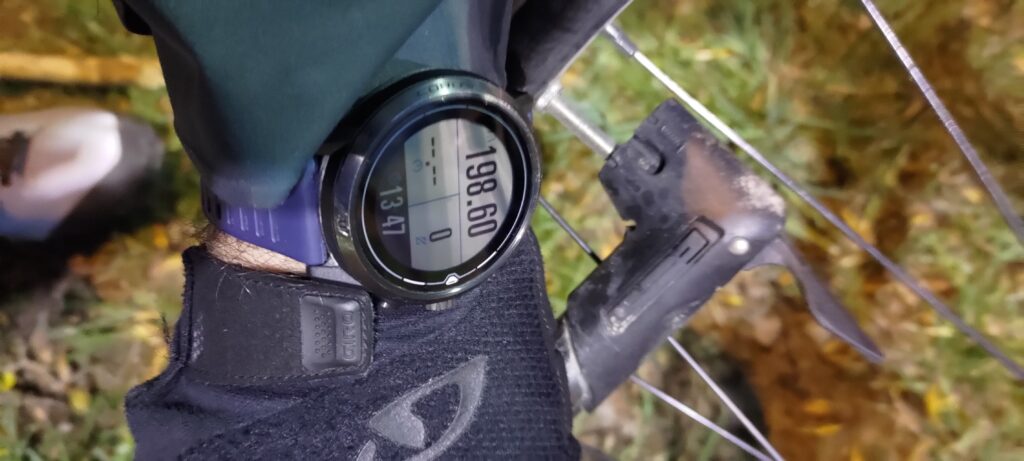 Montre indiquant 198.60 km au premier plan et une pompe à vélo en second plan