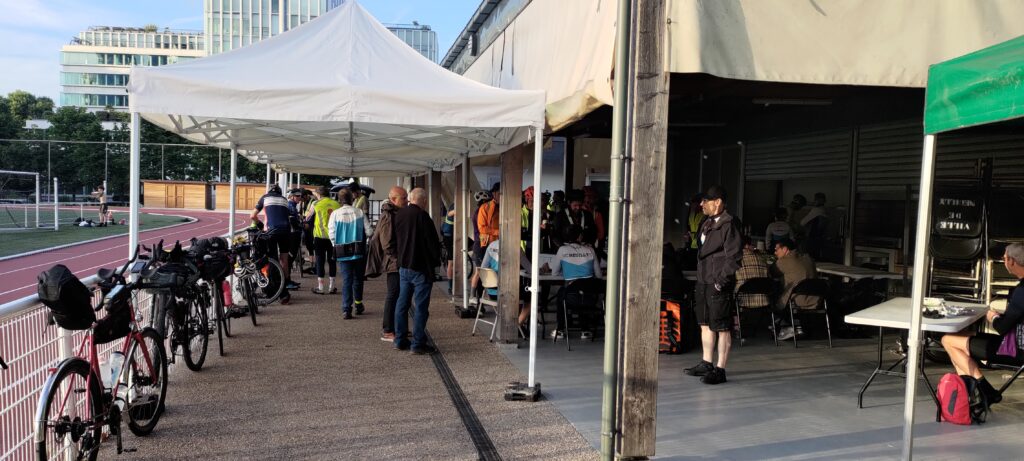 sur les bords d'un stade, des vélos, des personnes, des tables.