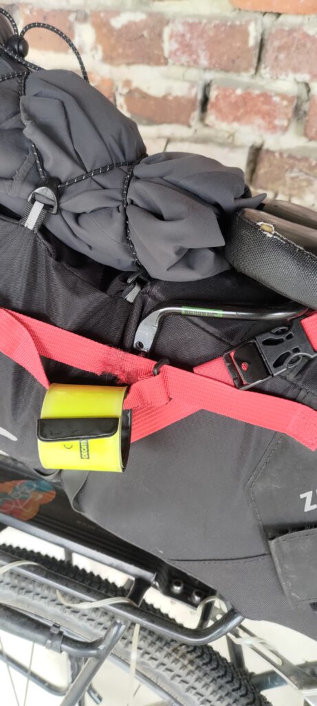 gros plan sur l'arrière d'un vélo, sur la sacoche de selle. On distingue un support métallique avec un trou qui laisse supposer qu'il manque quelque chose