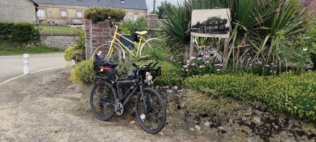 Un vélo posé sous un vélo décoratif peint en jaune