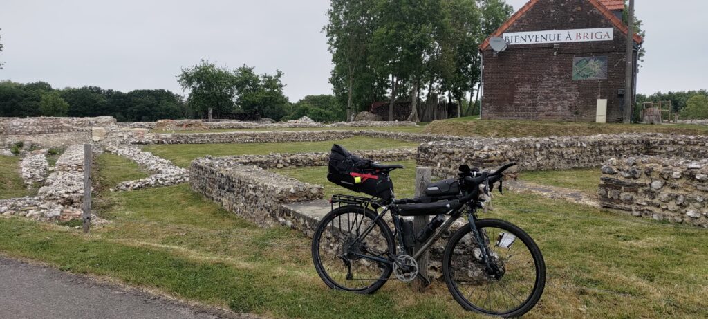 Un vélo type gravel posé devant des ruines gallo-romaines