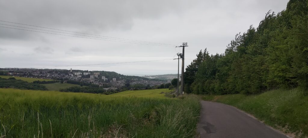 Une route en hauteur, en arrière plan une ville sur des falaises en bord de mer