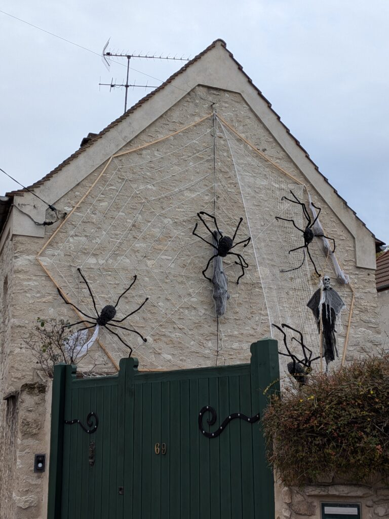 Maison décorée pour Halloween avec des araignées et une toile géante qui couvent 3 étages