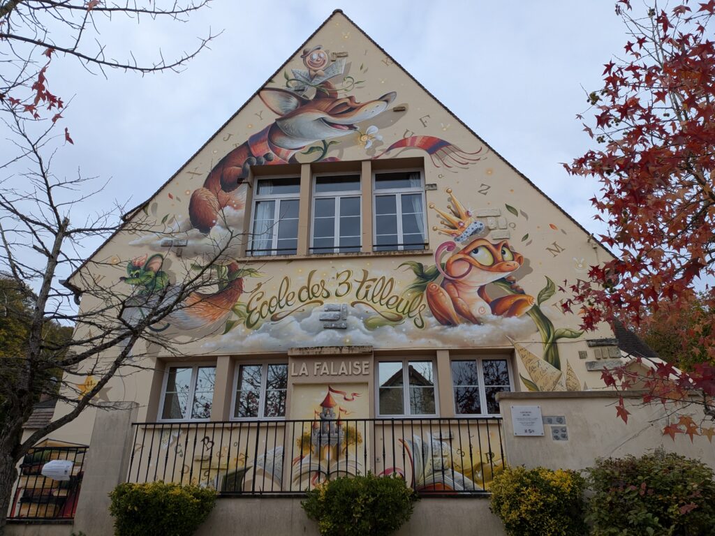 École des 3 tilleuls dont un mur est peint de très grands dessins de renards, grenouilles souris ambiance conte de fées