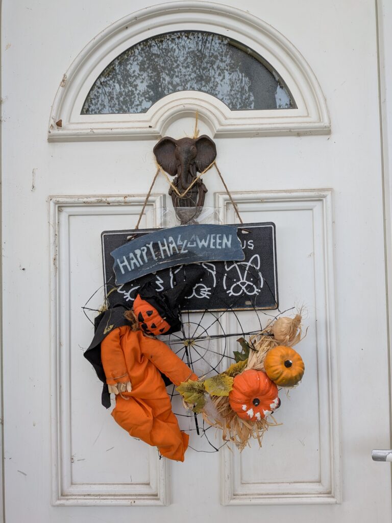 Maison décorée pour Halloween sur la porte d'entrée avec des minis citrouilles