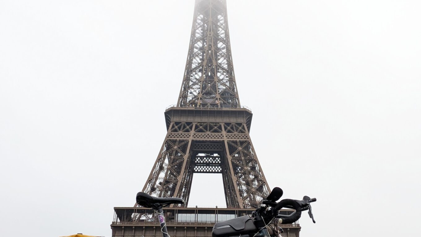 Une vélo au pied de la Tour Eiffel Photo en contre-plongée, le sommet de la tour est dans oes nuages