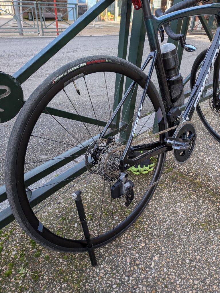vue de la roue arrière d'un vélo, une pompe est posée sur la roue