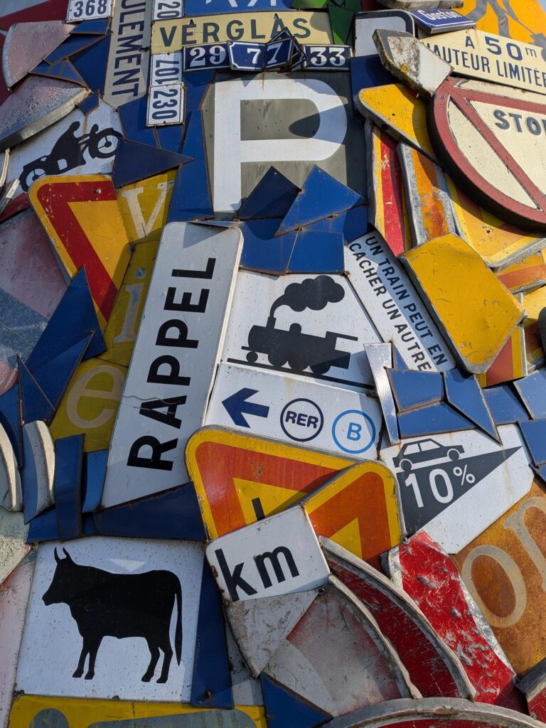 une œuvre composée d'une accumulation de panneaux routier de tout type, prise en plan serré