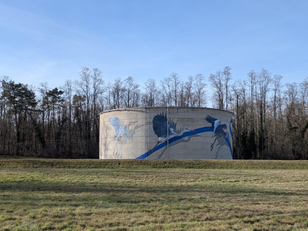 Une très grande citerne sur laquelle sont peintes des cigognes qui volent